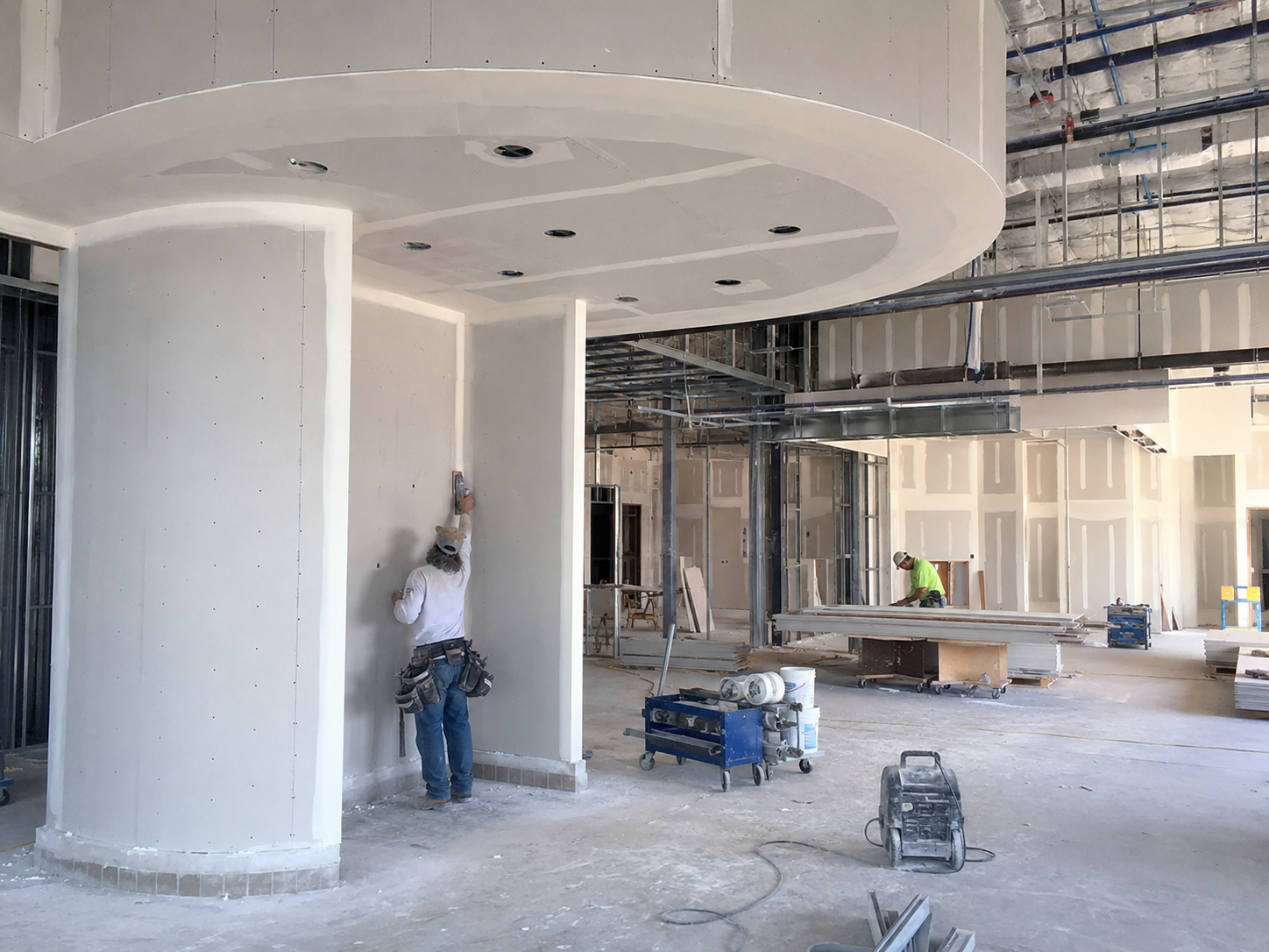 Commercial interior construction with curved drywall soffits, metal framing and finish work in progress